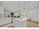 Open concept kitchen with island, white cabinets, and a view into the living room at 298 Kennerly Center Dr, Mooresville, NC 28115