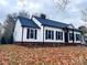 White house with black shutters, brick base, and a landscaped yard at 8520 Gruenewald Ln, Charlotte, NC 28210