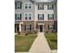 Two-story townhome with gray and brown siding, a walkway, and landscaping at 1725 Aspire St, Charlotte, NC 28262