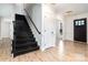 Bright entryway with black staircase, white door, and wood floors at 8823 Dartmoor Pl, Mint Hill, NC 28227