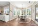 Cozy breakfast nook with round table, stylish chandelier, and large windows overlooking the backyard at 14104 Hollins Grove Ave, Huntersville, NC 28078