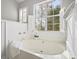 Relaxing primary bathroom with soaking tub, window, and white tile accents at 151 Paseo Dr, Mooresville, NC 28117