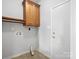 Bright laundry room with wood cabinets and built-in shelving at 151 Paseo Dr, Mooresville, NC 28117