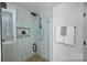 Modern bathroom with glass shower, built-in shelves, and black fixtures at 2019 Thurmond Pl # 13, Charlotte, NC 28205