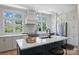 Modern kitchen with island, white cabinets, and black faucet at 2023 Thurmond Pl # 14, Charlotte, NC 28205