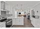 Open concept kitchen with island, white cabinets, and stainless steel appliances at 212 Tournament Sw Dr, Concord, NC 28025