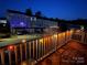Deck with string lights overlooking neighborhood townhomes and trees at 2133 Tupelo Grove Ln, Gastonia, NC 28054