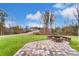 Stone fire pit with brick pavers and grassy backyard views at 3003 Whispering Creek Dr # 143, Indian Trail, NC 28079