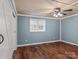 Bedroom with light blue walls, wood flooring, and barn door at 5660 Sherrills Ford Rd, Salisbury, NC 28147