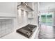 Modern gas cooktop with white subway tile backsplash and stainless steel range hood at 8740 Acadia Pkwy # 602, Sherrills Ford, NC 28673