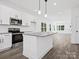 Bright kitchen with an island, stainless steel appliances, and white cabinets at 920 Sycamore Ave, Gastonia, NC 28052