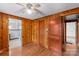 Empty bedroom with wood paneling, ceiling fan, and hardwood floors at 1755 N Main St, China Grove, NC 28023