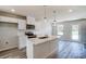 Modern kitchen with white cabinets, island, stainless steel appliances, and hardwood floors at 626 Monroe St, Statesville, NC 28677