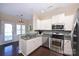 Modern kitchen featuring stainless steel appliances, white cabinetry, and granite countertops at 6307 Cory Bret Ln, Charlotte, NC 28278