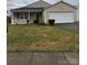 Tan house with attached garage and small front yard at 9315 Ames Hollow Rd, Charlotte, NC 28216