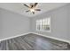 Bright bedroom with ceiling fan, wood-look floors, and large window at 10225 Nugget Place Rd, Midland, NC 28107