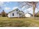 White house with a spacious yard, tree, and neighboring houses at 15 Stowe St, Lowell, NC 28098