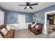 Cozy living room with brown sofas, hardwood floors, and a ceiling fan at 15 Stowe St, Lowell, NC 28098