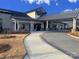 Clubhouse exterior with covered entryway, paver driveway, and landscaping at 2006 Gibbs Farm Dr, Monroe, NC 28110