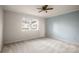 Bright bedroom with ceiling fan, light beige walls, and neutral carpeting at 2712 New Hamlin Way, Charlotte, NC 28210