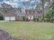 Brick house with attached two-car garage and well-maintained lawn at 10312 Woodview Cir, Charlotte, NC 28277