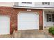 Attached garage with white door and brick exterior at 2022 University Heights Ln, Charlotte, NC 28213