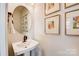 Chic powder room features a pedestal sink, round mirror, and framed art at 207 Tamala St, Davidson, NC 28036