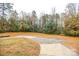 Large backyard with mature trees and a paved driveway at 2801 Eva Nw Dr, Concord, NC 28027