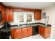 Kitchen with dark wood cabinets and black appliances at 2801 Eva Nw Dr, Concord, NC 28027