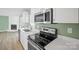 Modern kitchen with white countertops, stainless steel appliances, and a corner fireplace at 3433 Spinner Ct, Sherrills Ford, NC 28673