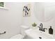 Small bathroom with pedestal sink and round mirror at 4936 Jane Ave, Charlotte, NC 28269