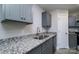 Close-up of the kitchen's granite countertop, stainless steel sink, and gray cabinets at 1014 Kansas St, Kannapolis, NC 28083