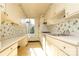 Kitchen with white cabinets, floral wallpaper, and a window overlooking trees at 1300 Queens Rd # 409, Charlotte, NC 28207