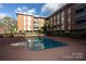 Community pool surrounded by landscaping and the apartment building at 1300 Queens Rd # 409, Charlotte, NC 28207