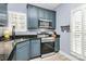 Updated kitchen featuring blue cabinetry, stainless steel appliances, and granite countertops at 1313 Anthem Ct, Charlotte, NC 28205