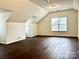 Large bonus room with window, dark brown laminate flooring, and sloped ceilings at 1364 Lloyd Nw Pl, Concord, NC 28027