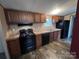 Modern kitchen with dark wood cabinets and black appliances at 3804 Crossing Creek Dr, Claremont, NC 28610