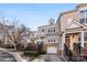 Three-story townhome with tan siding, black railings, and a two-car garage at 7108 Founders Club Ct, Charlotte, NC 28269