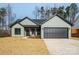 One-story home with light green siding, black garage door, and landscaping at 7673 Katherine Dr, Denver, NC 28037