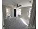 Bright main bedroom with gray carpet, ceiling fan, and access to the bathroom at 102 Old Rockwell Rd, China Grove, NC 28023