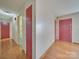 Hallway with hardwood floors and red doors at 28403 Hatley Farm Rd, Albemarle, NC 28001