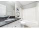 Modern bathroom with a black granite countertop, white vanity, and a bathtub at 2405 Sloan Dr, Charlotte, NC 28208