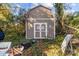 Tan colored storage shed in wooded area with tools at 1617 Parson St, Charlotte, NC 28205