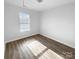 Well-lit bedroom featuring wood-look floors and a window with blinds at 4438 Cochran Farm Ln, Charlotte, NC 28269