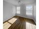 Bright bedroom with two windows, wood-look floors, and a ceiling fan at 4438 Cochran Farm Ln, Charlotte, NC 28269
