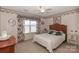 Charming bedroom with floral decor, ceiling fan, and natural light from a large window at 523 Fort Dobbs Rd, Statesville, NC 28625