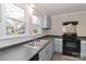 Kitchen showcasing gray cabinets, black appliances, and large windows offering natural light at 621 Spruce St, Mooresville, NC 28115