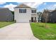 Two-story house with white siding, brown door, and a two-car garage. Landscaped lawn at 1009 20Th Avenue Se Loop, Hickory, NC 28602