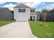 Two-story house with white siding, brown door, and a two-car garage. Nice curb appeal at 1009 20Th Avenue Se Loop, Hickory, NC 28602