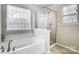 Bathroom with corner bathtub, shower, and window at 417 Stowe Rd, Belmont, NC 28012